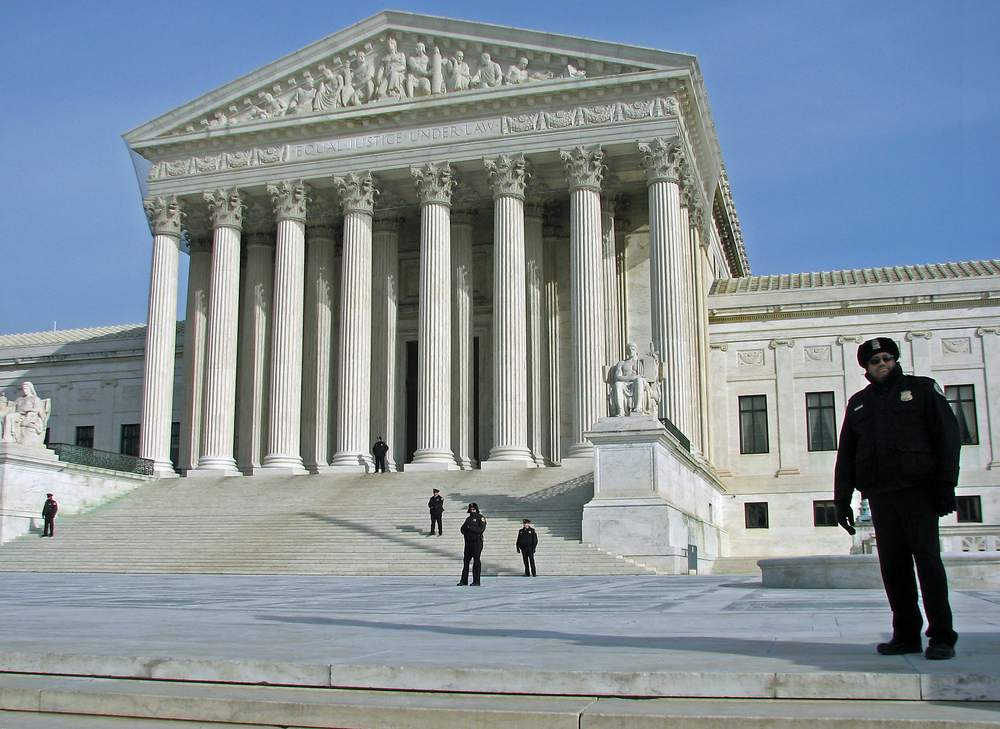 Supreme Court building with police officer standing on plaza