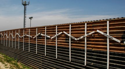 border wall with surveillance tower in background