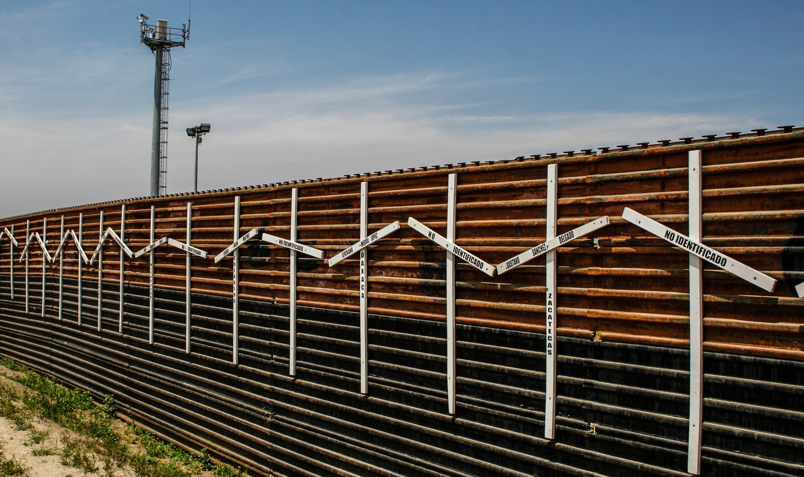 border wall with surveillance tower in background