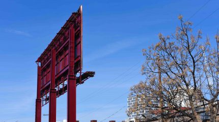 large red billboard seen from back against blue sky