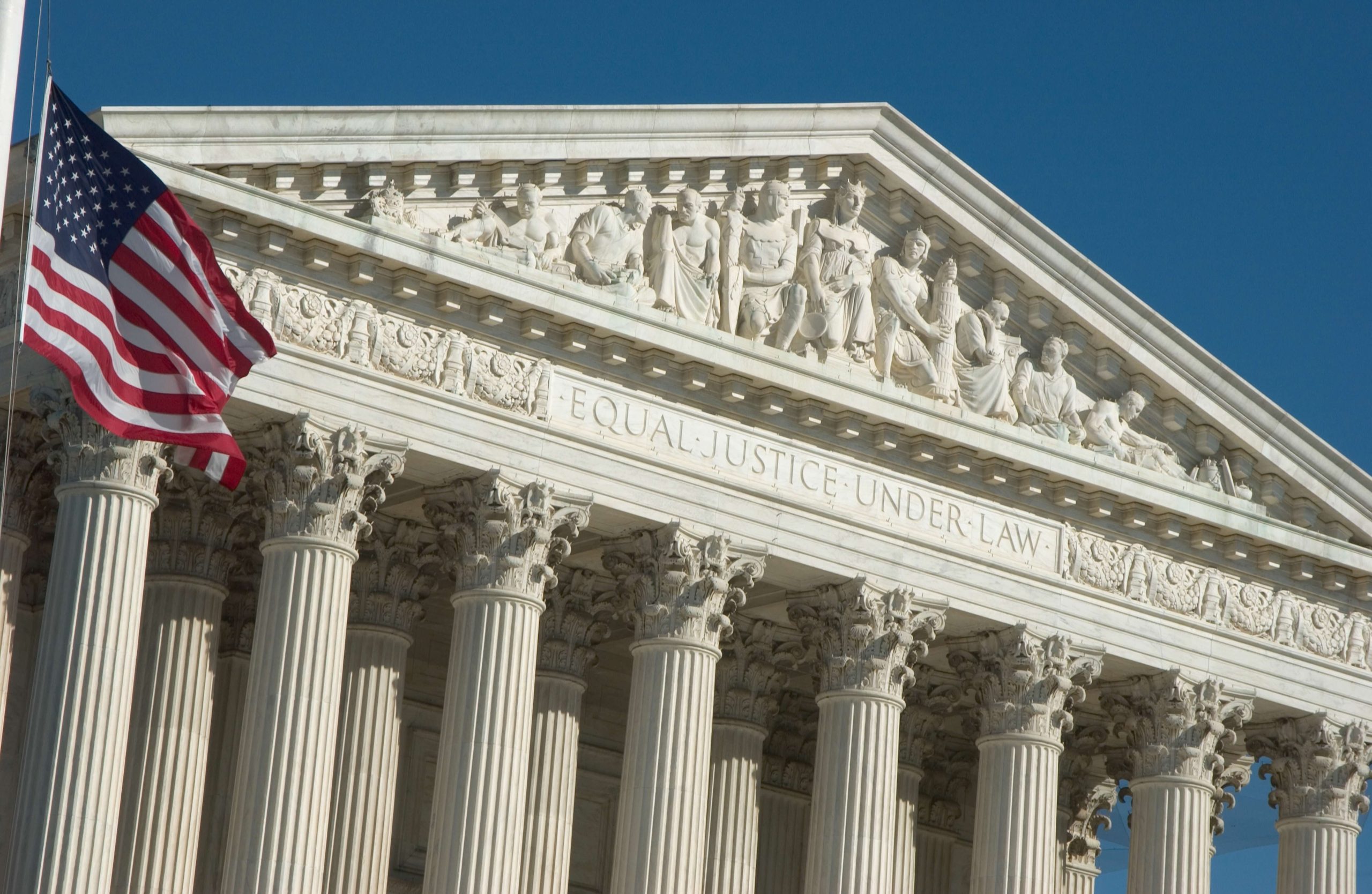 The front of the Supreme Court building and an American flag