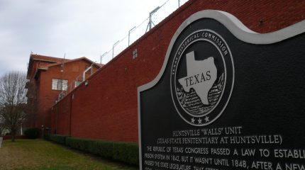 A sign and the exterior wall of the Hunstville prison