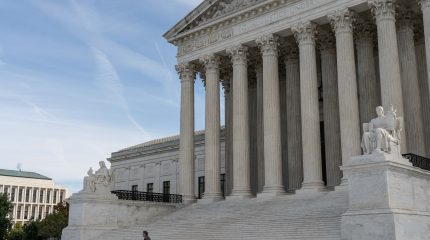 Person walks in front of the Supreme Court of the United States.