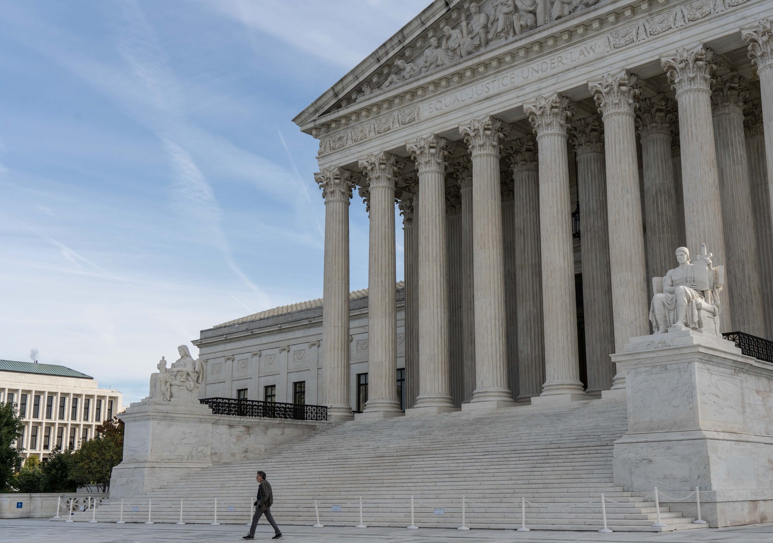 Person walks in front of the Supreme Court of the United States.