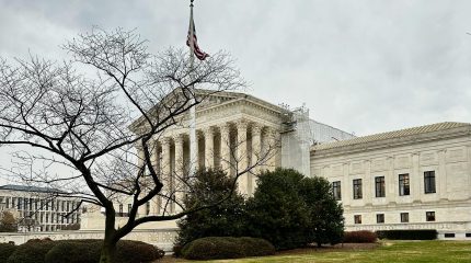 Supreme Court building under a clouded sky