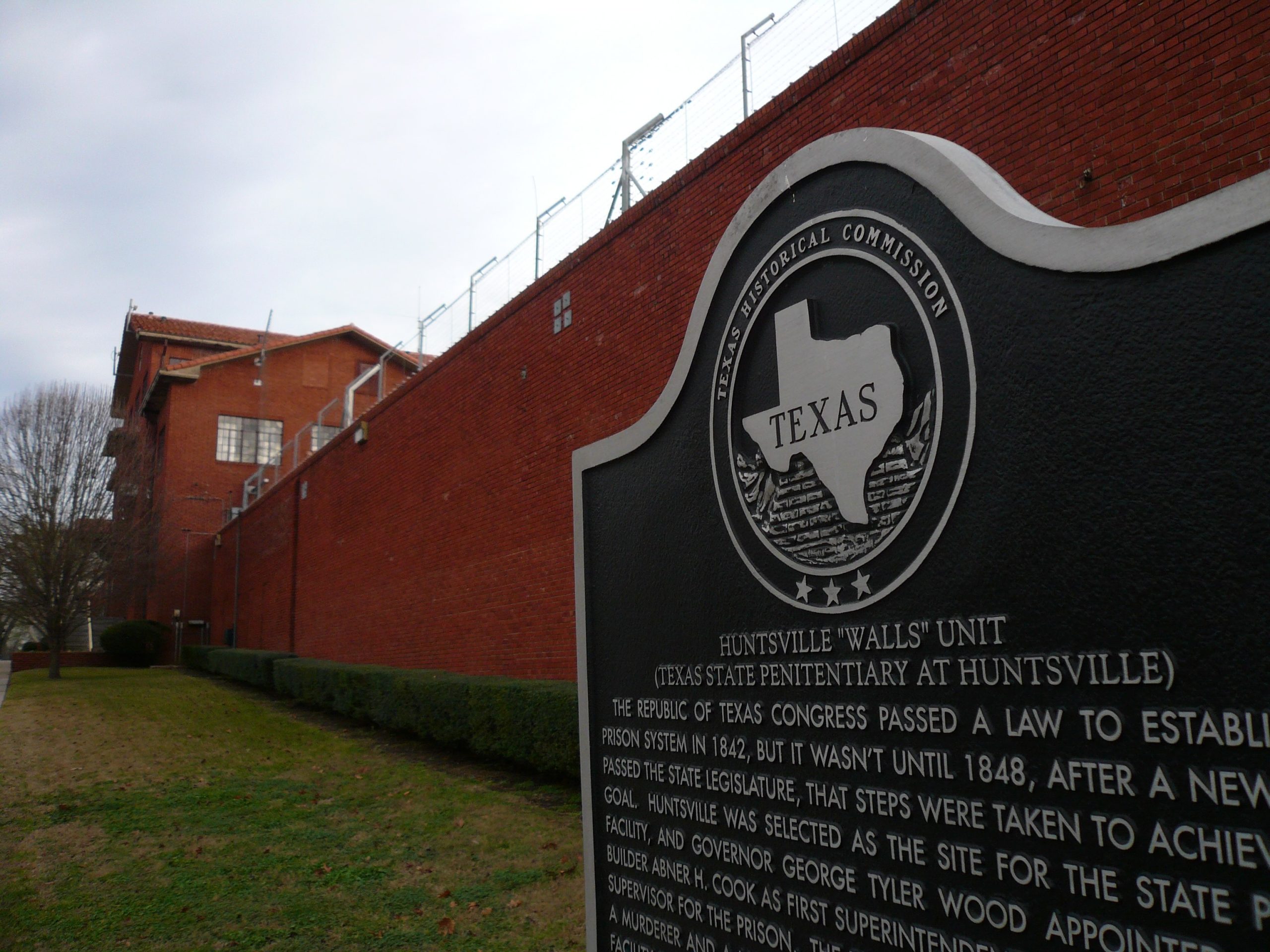 Texas state historic marker sign in front of prison wall